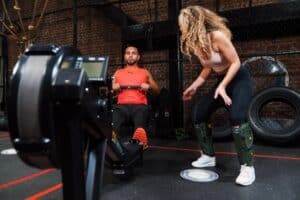 man and woman working out with rowing machine